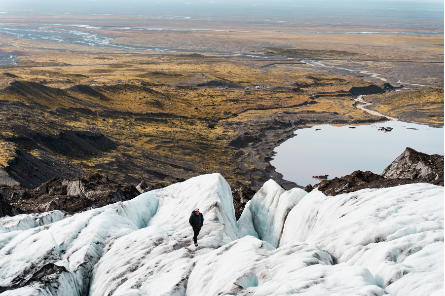 (Visual of a receding glacier and the ocean in the distance. Photo Credit: Adam Moore)